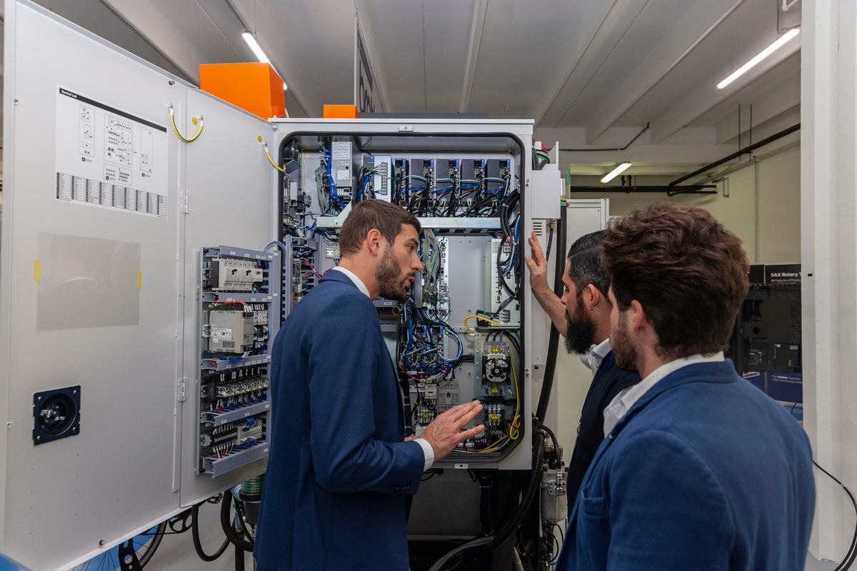 Tecnici davanti al quadro elettrico di una macchina CNC