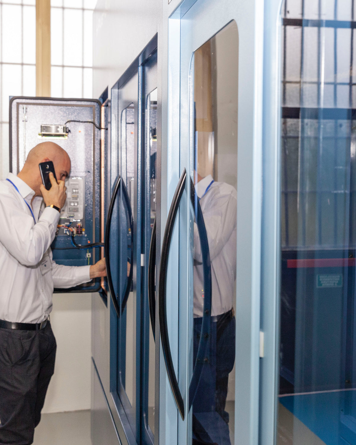 Visitatore al telefono accanto a macchina CNC showroom IMU