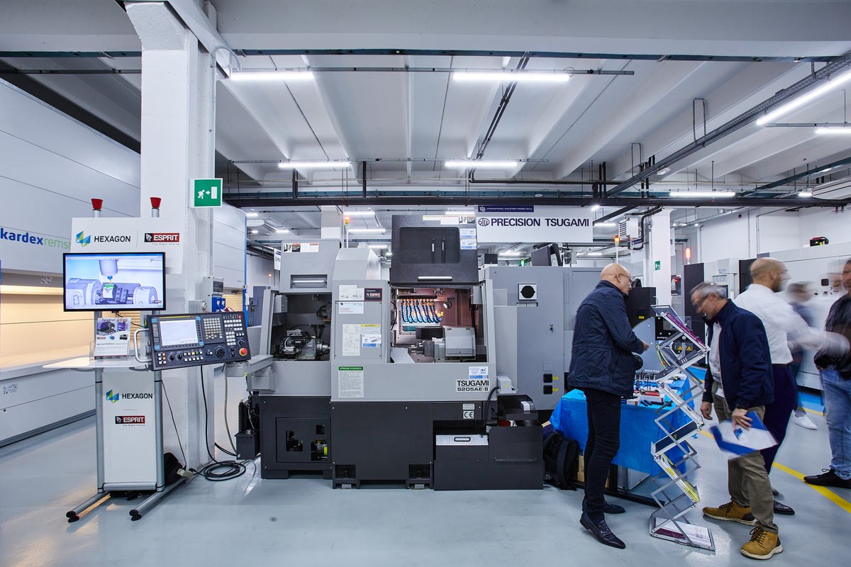 Visitatori in showroom IMU davanti a tornio CNC